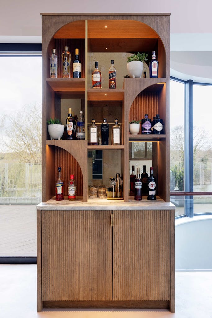 Bespoke modern kitchen in Esher with fluted oak cabinetry and leathered stone island by HUX London