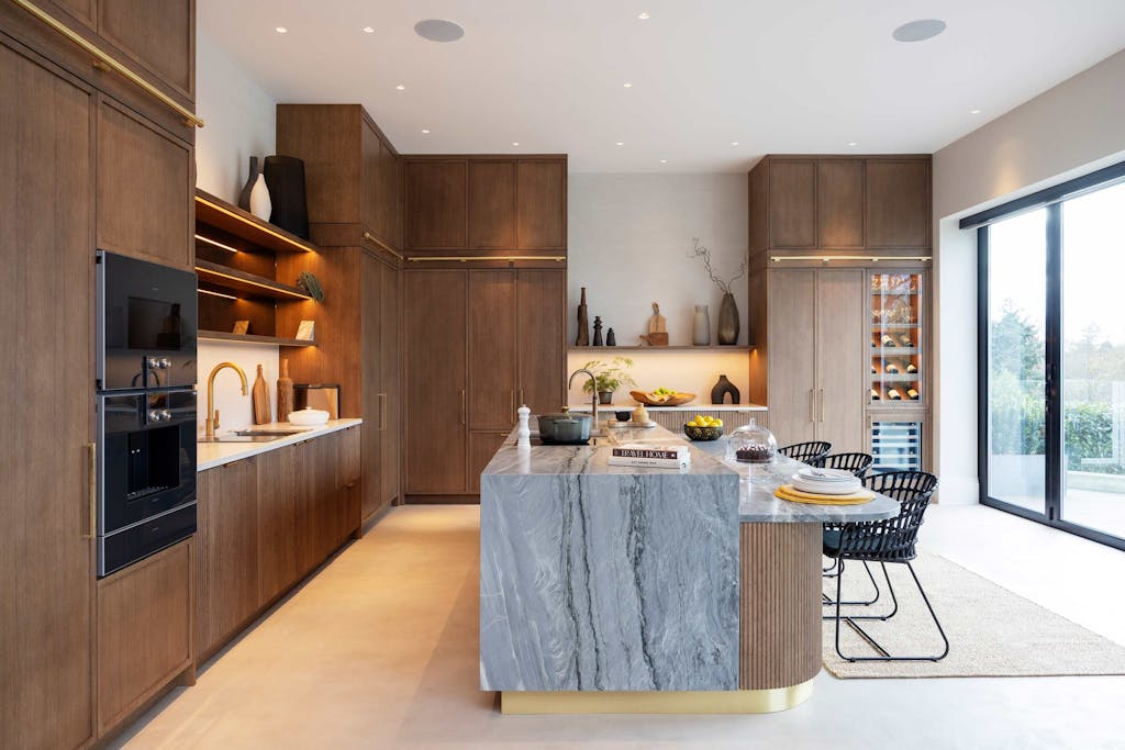 Bespoke modern kitchen in Esher with fluted oak cabinetry and leathered stone island by HUX London
