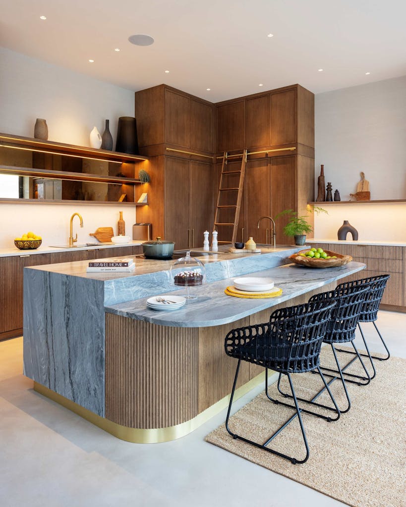 Bespoke modern kitchen in Esher with fluted oak cabinetry and leathered stone island by HUX London