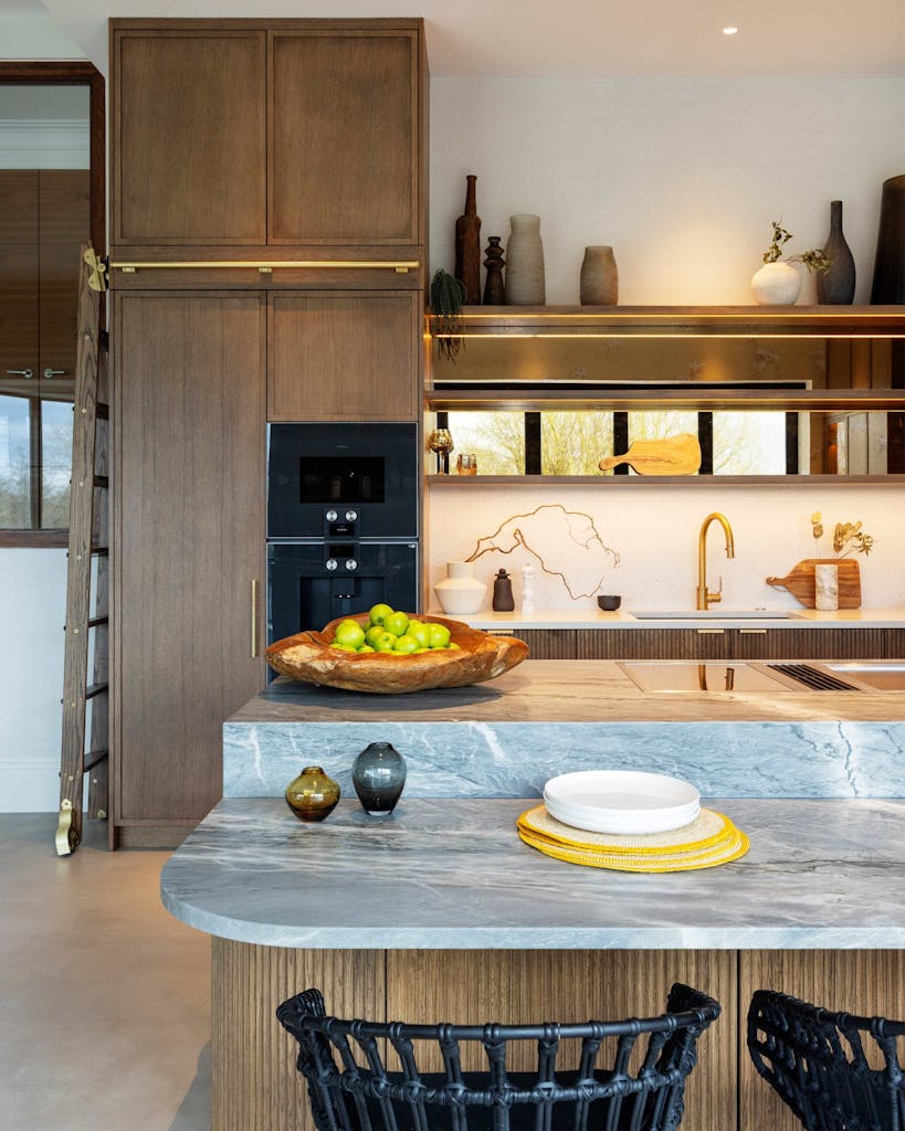 Bespoke modern kitchen in Esher with fluted oak cabinetry and leathered stone island by HUX London