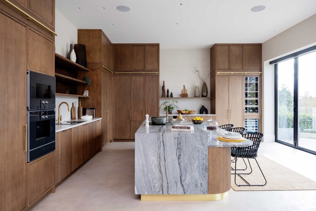 Bespoke modern kitchen in Esher with fluted oak cabinetry and leathered stone island by HUX London