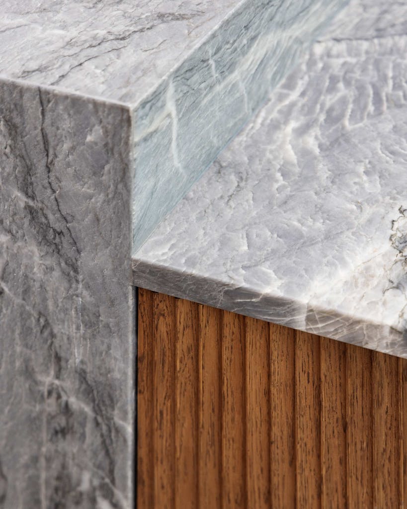 Bespoke modern kitchen in Esher with fluted oak cabinetry and leathered stone island by HUX London